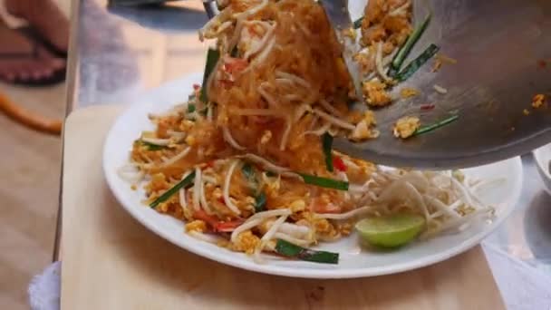 Cook sätter nudlar med räkor på tallriken. Steg för steg matlagning Pad Thai. Thailändsk mat. Närbild. 4K — Stockvideo