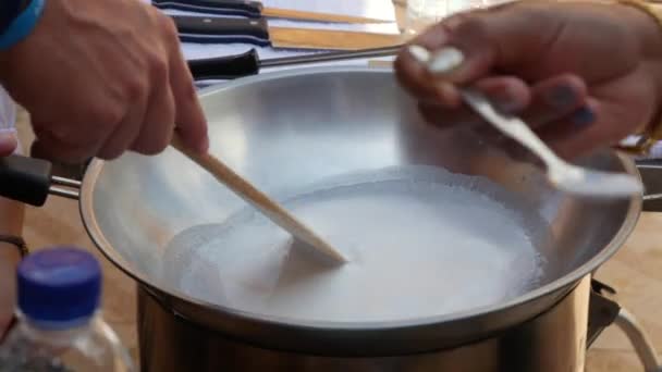 Mão masculina mexendo leite de coco fervente em wok. Passo a passo cozinhar arroz pegajoso tailandês. Cozinha tailandesa. Fecha a porta. 4k — Vídeo de Stock