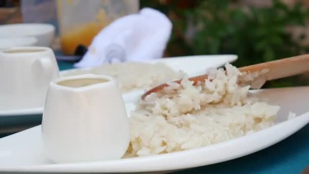 Перед подачей женщина положила на тарелку тайский липкий рис. Тайская кухня. Крупный план. 4k — стоковое видео