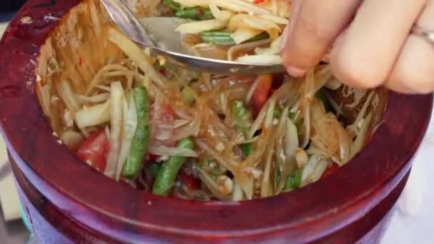 Mujeres tailandesas preparando ensalada de papaya verde som tam en mortero de madera con mortero. De cerca. 4k — Vídeo de stock