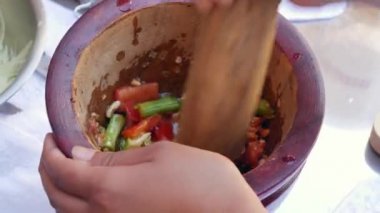 Tay kadınlar havaneli ile ahşap harç yeşil papaya salatası som tam hazırlanıyor. Yakından Kapatın. 4k