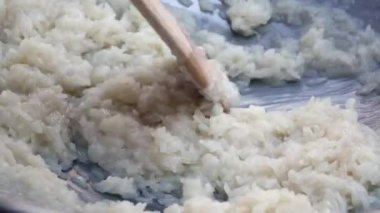 Erkek el wok hindistan cevizi sütü ile pirinç karıştırın. Adım adım Pişirme Tay yapışkan pirinç. Tay mutfağı. Closeup. 4k