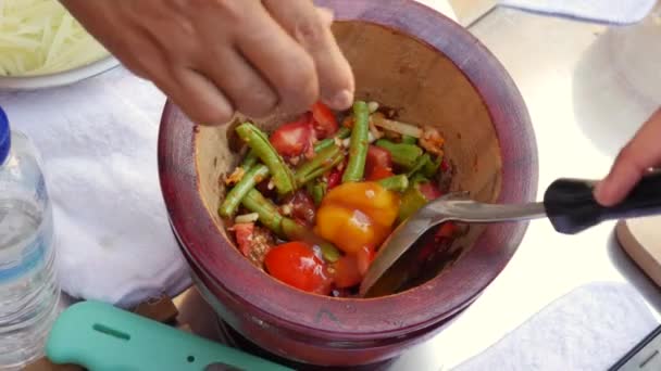 Mulheres tailandesas preparando salada de mamão verde som tam em argamassa de madeira com pilão. Fecha. 4k — Vídeo de Stock