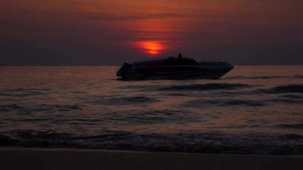 シルエットボートは、背景の夕日に海に航海します。4k — ストック動画