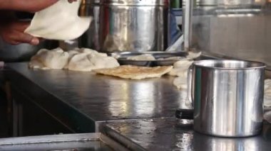 Erkek elleri Roti Canai denilen geleneksel Hint yemekleri yapıyor. 4k