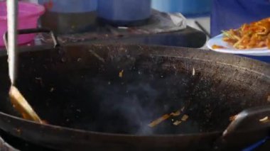 Bir sokak pazarında karides ve sebze ile bir wok erişte pişirin. 4k