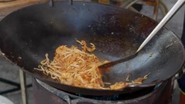 Bir sokak pazarında karides ve sebze ile bir wok erişte pişirin. 4k