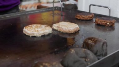 Hamburger pişirmek. Sığır eti veya domuz büyük, gür, lezzetli pirişlet tavada ızgara. Closeup. 4k