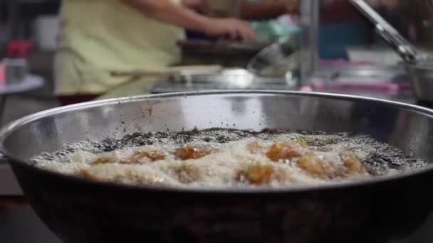 面包鸡在油炸锅里烹饪，在街头当地市场的锅里装满了热的冒泡植物油。4k — 图库视频影像