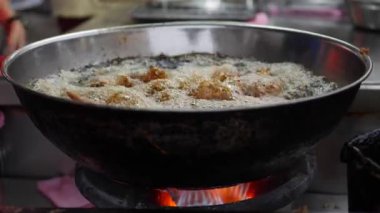 Derin bir fritözde ekmekli tavuk pişirme sıcak dolu, sokak yerel pazarda wok içinde köpüren bitkisel yağ. 4k