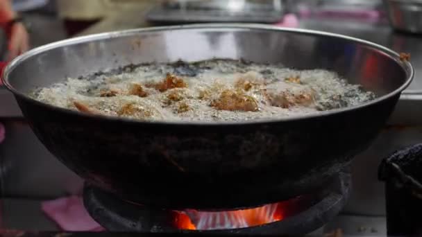 Breaded chicken cooking in a deep fryer full of hot, bubbling vegetable oil in wok at street local market. 4k — Stock Video