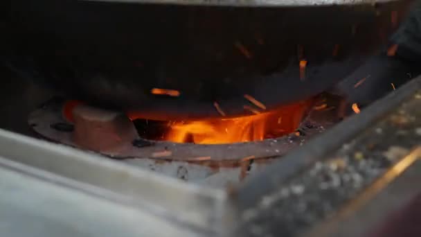 Nahaufnahme beim Verbrennen von Kohle in einem Feuer. leuchtend orangefarbene Flamme brennt im Inneren. 4k — Stockvideo