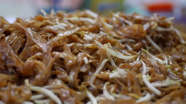 Cibo asiatico di strada. Tagliatelle di riso fritto piatto tradizionale e popolare in Asia. Primo piano. 4k — Video Stock