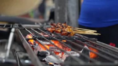 Sokak yerel pazarda pişirilen çubuklar üzerinde geleneksel ızgara et. Satay bbq. Closeup. 4k