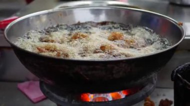 Derin bir fritözde ekmekli tavuk pişirme sıcak dolu, sokak yerel pazarda wok içinde köpüren bitkisel yağ. 4k