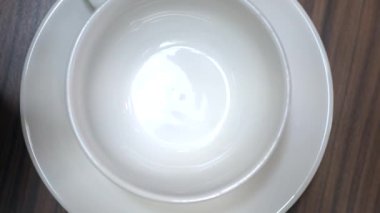 Kadınların elleri kafede çaydanlık beyaz bir fincan içine çay dökün. Bir yakın çekimin en iyi görünümü. Çay içmek. 4k