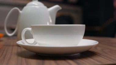 Kadınların elleri kafede çaydanlık beyaz bir fincan içine çay dökün. Closeup. Çay içmek. 4k