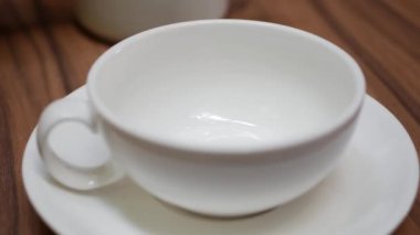 Kadınların elleri kafede çaydanlık beyaz bir fincan içine çay dökün. Closeup. Çay içmek. 4k