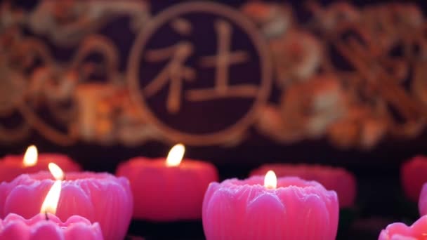 Пламя от горящих розовых свечей в китайском родовом храме. 4k — стоковое видео