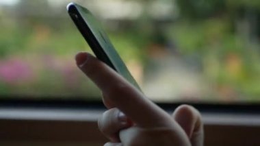 Kadın elleri cep telefonundan otobüse biniyor. Otobüs, arka planda geçen şehir ile pencere akıllı telefon kullanarak kadın closeup vurdu. E-postalar okuma. Mesaj mesajı. 4k