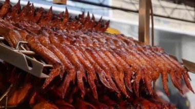 Pişmiş tavuk parçaları ızgara bir sürü mutfakta metal şiş asmak. Asya, Tayland, Japon, Oryantal mutfağı. Bir ızgara yakın çekim. Sokak yemeği. Lezzetli kızarmış et kümes hayvanları. Üretim