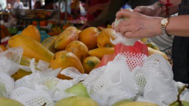 Bir kadın seçer ve Asya sokak pazarında guava satın alır. 4k