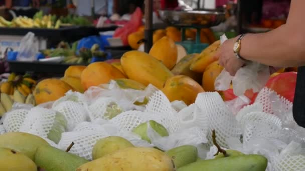Μια γυναίκα επιλέγει και αγοράζει γκουάβα στην ασιατική αγορά του δρόμου. 4K — Αρχείο Βίντεο