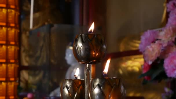 Vlam van brandende olie kaars lamp in boeddhistische tempel. Close-up. 4k — Stockvideo