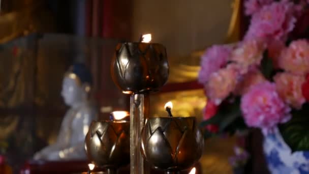 Chama da lâmpada de vela de óleo ardente no templo budista. Fecha a porta. 4k — Vídeo de Stock