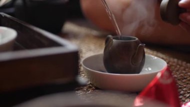 Geleneksel Çin gongfu veya kung fu çay töreni. Kaynar su su ısıtıcısına dökülür. Çay ustası yeşil çayla çaydanlığa su döker. Geleneksel Çin kültürünün unsuru. Closeup. 4k
