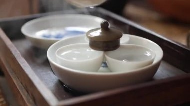 Çay ustası çay seremonisinden önce çay fincanlarını yıkıyor ve ısıtıyor. Geleneksel Çin gongfu veya kung fu çay töreni. Geleneksel Çin kültürünün unsuru. Closeup. 4k