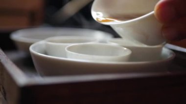 Çay ustası gaiwan veya zhong için çay bardakiçine fermente yeşil çay döker. Geleneksel Çin gongfu veya kung fu çay töreni. Geleneksel Çin kültürünün unsuru. Closeup. 4k