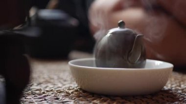 Geleneksel Çin gongfu veya kung fu çay töreni. Kaynar su su ısıtıcısına dökülür. Çay ustası yeşil çayla çaydanlığa su döker. Geleneksel Çin kültürünün unsuru. Closeup. 4k