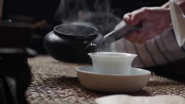 Geleneksel Çin gongfu veya kung fu çay töreni. Kaynar su gaiwan içine dökülür. Çay ustası yeşil çay ile gaiwan veya zhong içine su döker. Geleneksel Çin kültürünün unsuru. Closeup. 4k