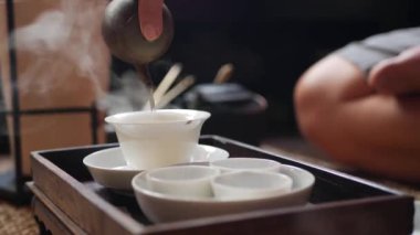 Geleneksel Çin gongfu veya kung fu çay töreni. Çay ustası gaiwan veya zhong içine yeşil çay döker. Geleneksel Çin kültürünün unsuru. Closeup. 4k