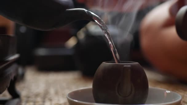 伝統的な中国のゴンフーやカンフー茶の儀式。沸騰したお湯がやかんに注ぐ。ティーマスターは緑茶でティーポットに水を注ぎます。中国の伝統文化の要素。クローズ アップ。4k — ストック動画