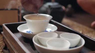 Geleneksel Çin gongfu veya kung fu çay töreni. Çay ustası gaiwan veya zhong içine yeşil çay döker. Geleneksel Çin kültürünün unsuru. Closeup. 4k