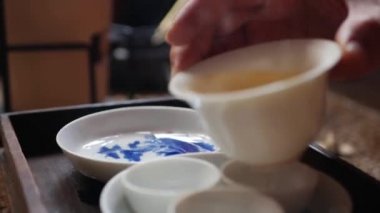 Çay ustası gaiwan veya zhong için çay bardakiçine yeşil çay döker. Geleneksel Çin gongfu veya kung fu çay töreni. Geleneksel Çin kültürünün unsuru. Closeup. 4k