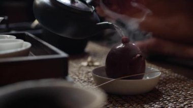 Geleneksel Çin gongfu veya kung fu çay töreni. Kaynar su su ısıtıcısına dökülür. Çay ustası yeşil çayla çaydanlığa su döker. Geleneksel Çin kültürünün unsuru. Closeup. 4k