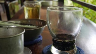 Müşteri içmeden önce siyah kahveye buz koyar. Kafede Vietnam geleneksel phin Filtre kullanarak. Ca phe den da. Closeup. 4k