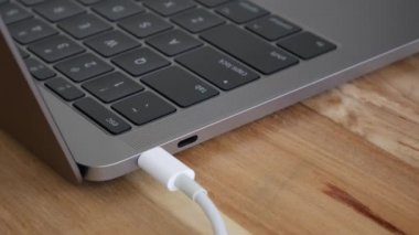 Beyaz güçusb-c veya Type C Kablosunu dizüstü bilgisayarlara dönüştüren erkek el, Usb-C bağlantı noktasını bilgisayarlar. Yıldırım konektörü. Closeup. 4k