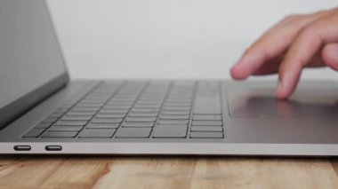 Erkek eller trackpad kullanın ve dizüstü bilgisayar klavye, ofis çalışmaları için kişisel bilgisayar kullanımı yazın. Closeup. 4k