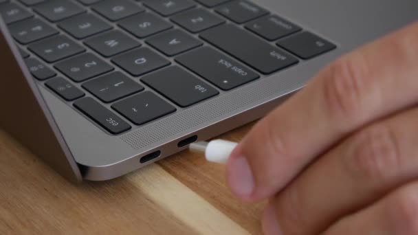 Mano maschio inserendo un cavo USB-C o Tipo C di alimentazione bianca e un cavo flash drive nero in una porta USB-C per computer portatili. Connettore Thunderbolt. Primo piano. 4k — Video Stock