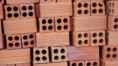 Şantiyede dışarıda kırmızı tuğla yığını.