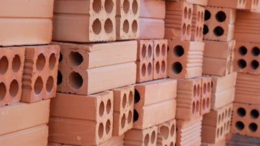 Şantiyede dışarıda kırmızı tuğla yığını.