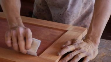 Joiner masanın üzerinde zımpara ile elle ahşap öğütür. Zanaat fabrika otantik. İnşaat aletlerinin yakınlaştırılması. Yavaş çekim