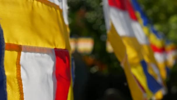 Buddhist prayer flags swaying in the wind in the rays of the rising sun in a temple. Closeup Slow Motion Footage. Shallow depth of field — Stock Video