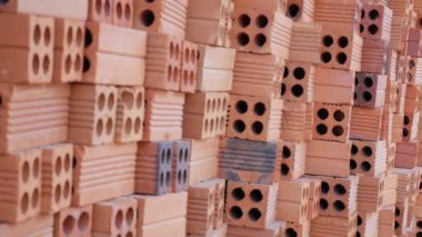 Şantiyede dışarıda kırmızı tuğla yığını.