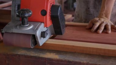 Zanaatkar zıpzıp makinesini kullanırken marangozluk atölyesinde çalışır. İşçi taşlama ile mobilya parlatma. İnşaat aletlerinin yakınlaştırılması. Yavaş çekim