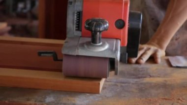 Zanaatkar zıpzıp makinesini kullanırken marangozluk atölyesinde çalışır. İşçi taşlama ile mobilya parlatma. İnşaat aletlerinin yakınlaştırılması. Yavaş çekim
